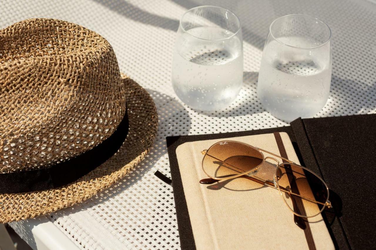 Toscana Charme Resort Tirrenia Dış mekan fotoğraf A hat, sunglasses, and a book